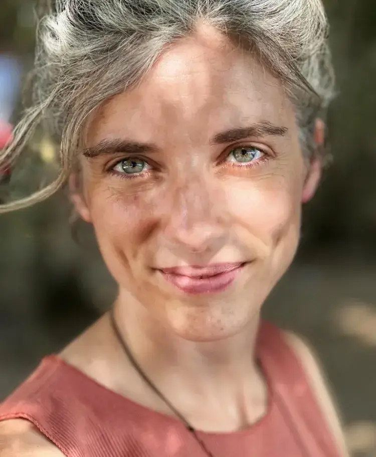 Maina Petry, Vedic Meditation teacher in Detroit, smiling outdoors in natural light
